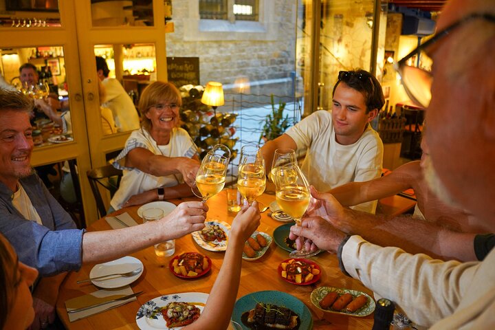 A small group enjoys tapas and wine at a bar in Barcelona's Gothic Quarter during a food tour, photo 1 | wizardtrip