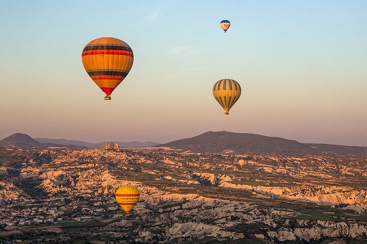 Balão de ar quente a flutuar sobre as chaminés de fada da Capadócia ao nascer do sol, foto 13 | wizardtrip