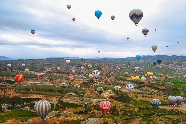 Balão de ar quente a flutuar sobre as chaminés de fada da Capadócia ao nascer do sol, foto 15 | wizardtrip