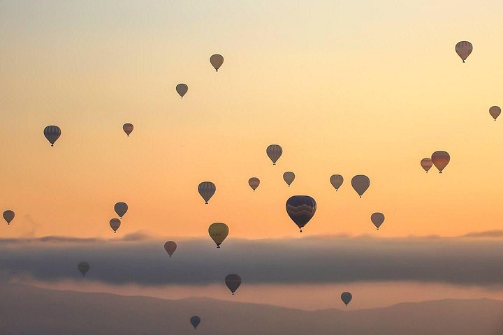 Balão de ar quente a flutuar sobre as chaminés de fada da Capadócia ao nascer do sol, foto 16 | wizardtrip