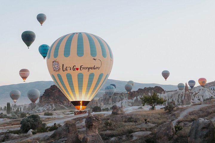 Balão de ar quente a flutuar sobre as chaminés de fada da Capadócia ao nascer do sol, foto 25 | wizardtrip