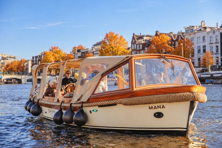 Eine malerische Grachtenfahrt in Amsterdam, vorbei an historischen Gebäuden und Brücken, Foto 6 | wizardtrip