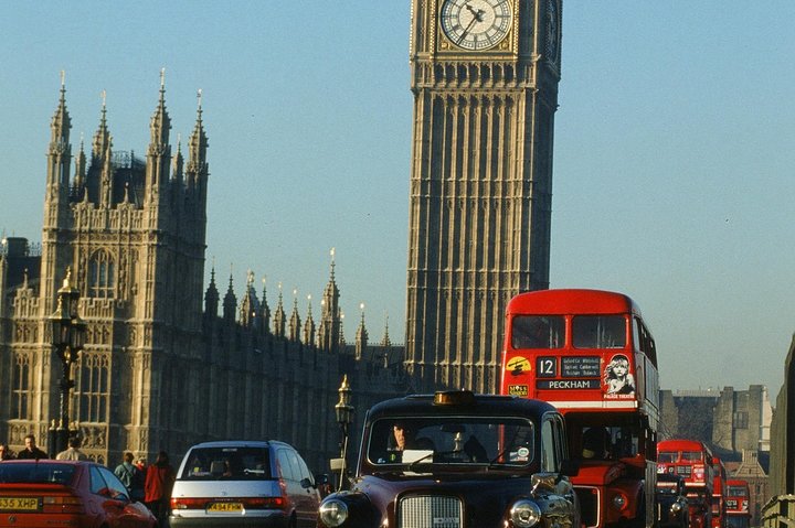 A classic London Black Cab driving past iconic landmarks like the Houses of Parliament and Big Ben, photo 7 | wizardtrip