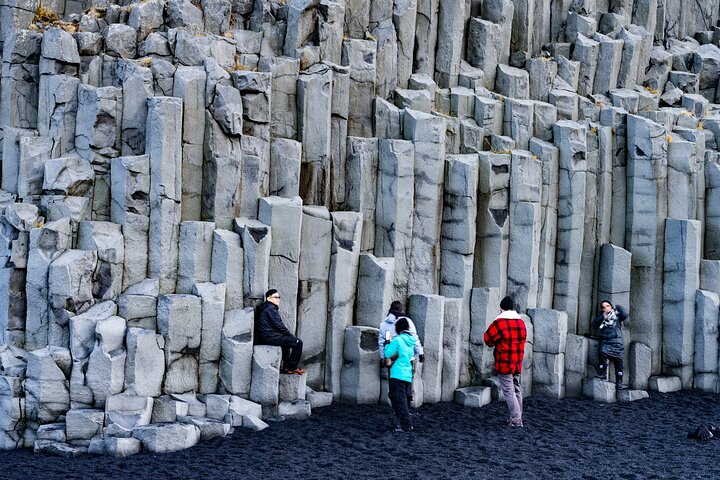 Turister som utforsker Islands dramatiske sørkyst med fosser, isbreer og svarte sandstrender, foto 11 | wizardtrip