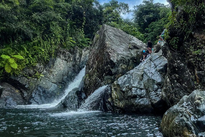 Liten gruppe som utforsker El Yunque regnskog med naturlige vannsklier og frodig vegetasjon, foto 18 | wizardtrip