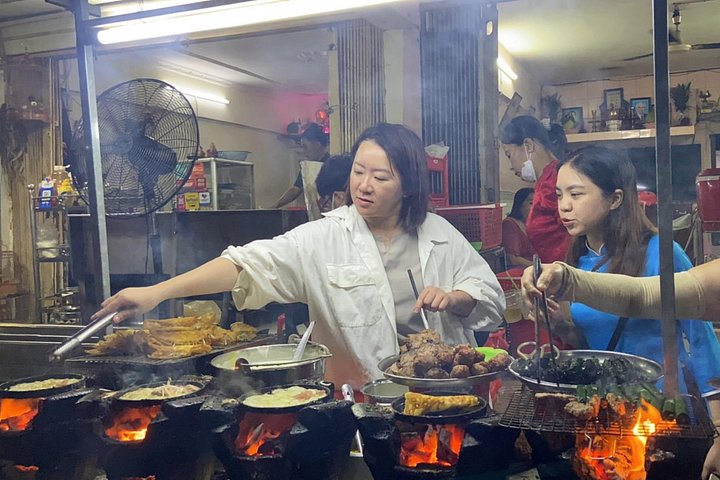 Experience Ho Chi Minh City's vibrant nightlife on a motorbike tour with a female guide, tasting local snacks and seeing city lights, photo 15 | wizardtrip