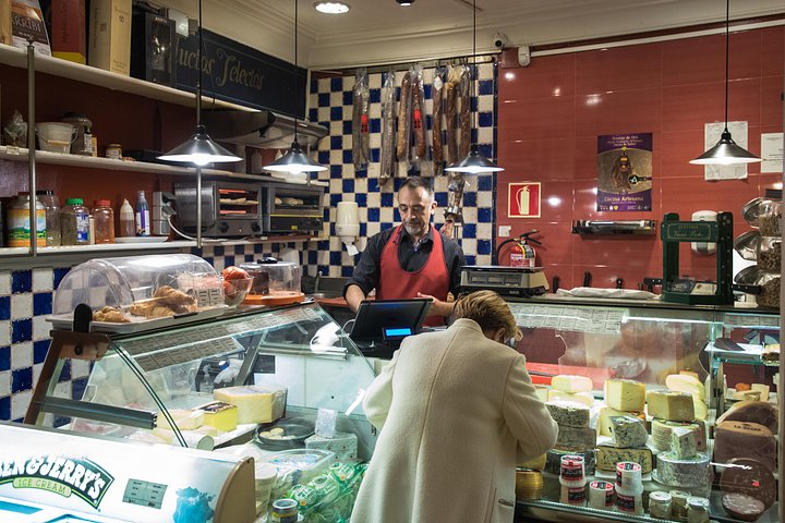 En liten grupp njuter av tapas och vin på en traditionell bar i Madrids historiska centrum, foto 10 | wizardtrip