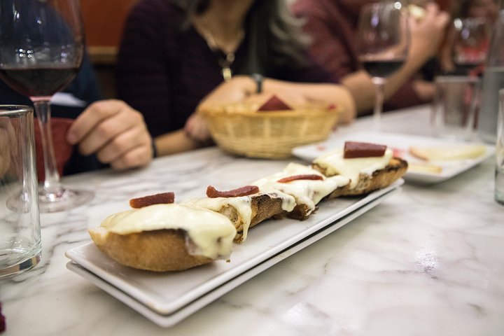 En liten grupp njuter av tapas och vin på en traditionell bar i Madrids historiska centrum, foto 22 | wizardtrip
