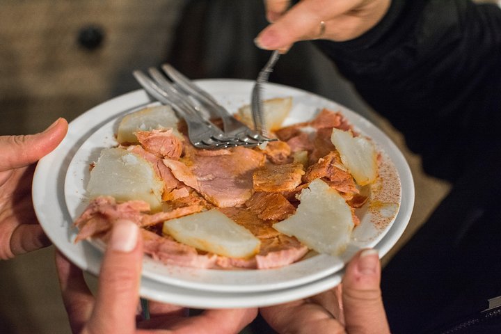 En liten grupp njuter av tapas och vin på en traditionell bar i Madrids historiska centrum, foto 24 | wizardtrip