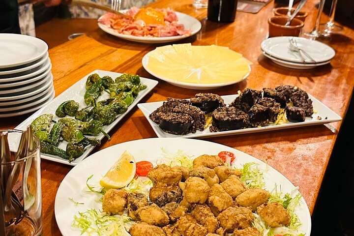 En liten grupp njuter av tapas och vin på en traditionell bar i Madrids historiska centrum, foto 31 | wizardtrip