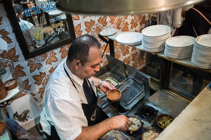 En liten grupp njuter av tapas och vin på en traditionell bar i Madrids historiska centrum, foto 36 | wizardtrip