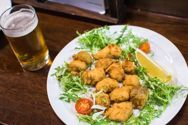 En liten grupp njuter av tapas och vin på en traditionell bar i Madrids historiska centrum, foto 46 | wizardtrip