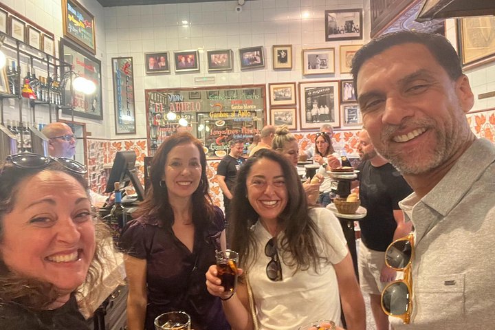 En liten grupp njuter av tapas och vin på en traditionell bar i Madrids historiska centrum, foto 51 | wizardtrip