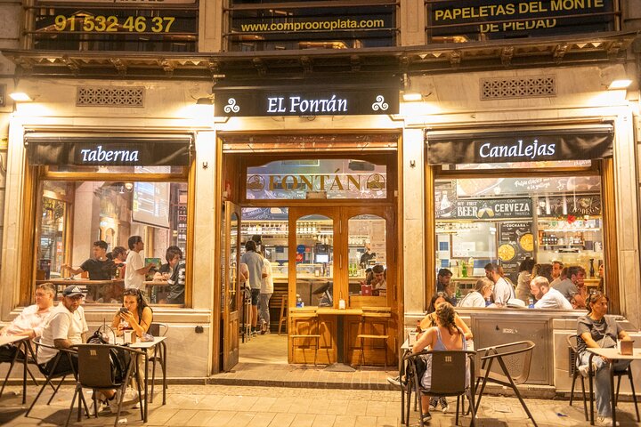 En liten grupp njuter av tapas och vin på en traditionell bar i Madrids historiska centrum, foto 61 | wizardtrip