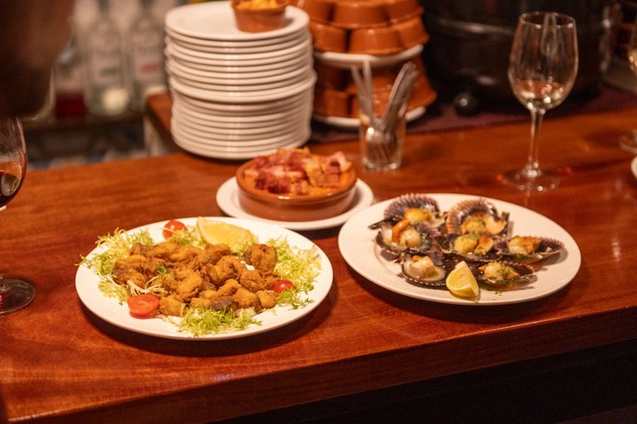 En liten grupp njuter av tapas och vin på en traditionell bar i Madrids historiska centrum, foto 62 | wizardtrip