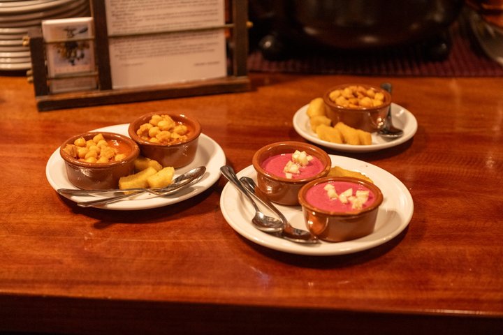 En liten grupp njuter av tapas och vin på en traditionell bar i Madrids historiska centrum, foto 64 | wizardtrip
