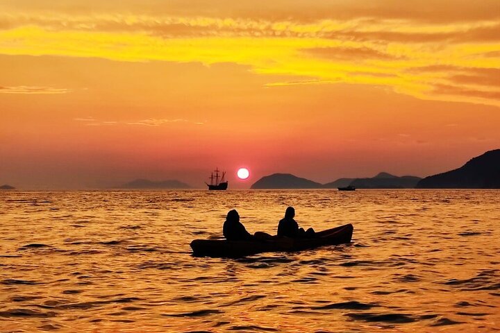 Kajakkers peddelen langs de kust van Dubrovnik bij zonsondergang, met de stadsmuren op de achtergrond, foto 6 | wizardtrip