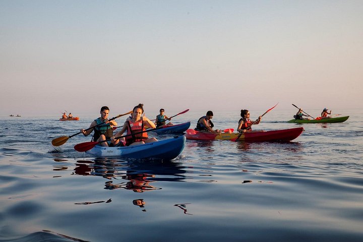 Kajakkers peddelen langs de kust van Dubrovnik bij zonsondergang, met de stadsmuren op de achtergrond, foto 7 | wizardtrip
