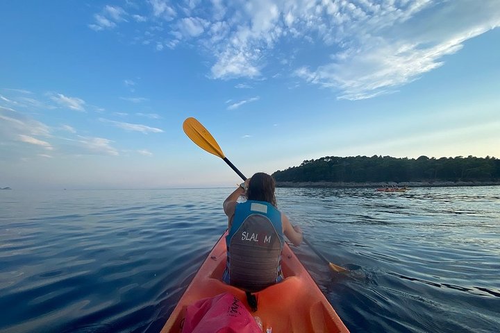 Kajakkers peddelen langs de kust van Dubrovnik bij zonsondergang, met de stadsmuren op de achtergrond, foto 8 | wizardtrip
