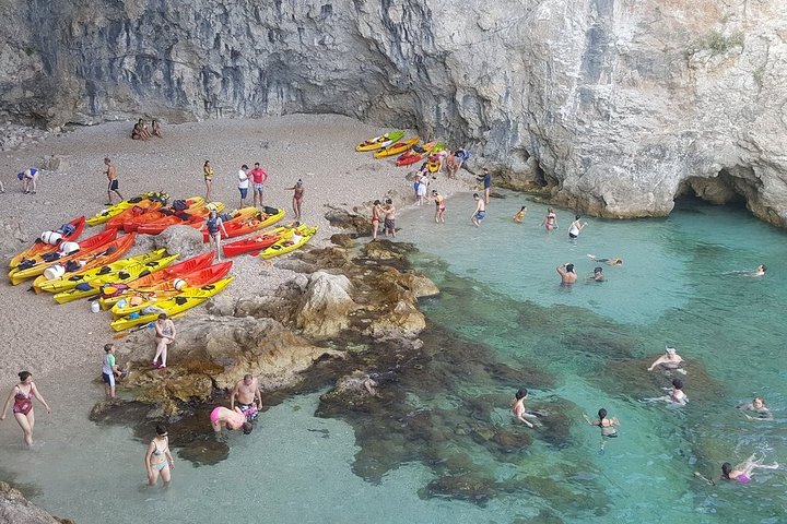 Kajakkers peddelen langs de kust van Dubrovnik bij zonsondergang, met de stadsmuren op de achtergrond, foto 9 | wizardtrip
