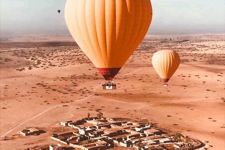 Hot air balloon floating over Marrakech at sunrise with Atlas Mountains view, photo 10 | wizardtrip
