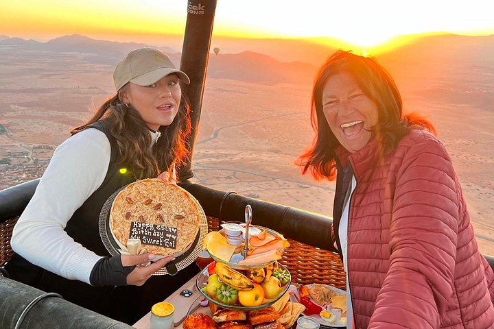 Hot air balloon floating over Marrakech at sunrise with Atlas Mountains view, photo 21 | wizardtrip