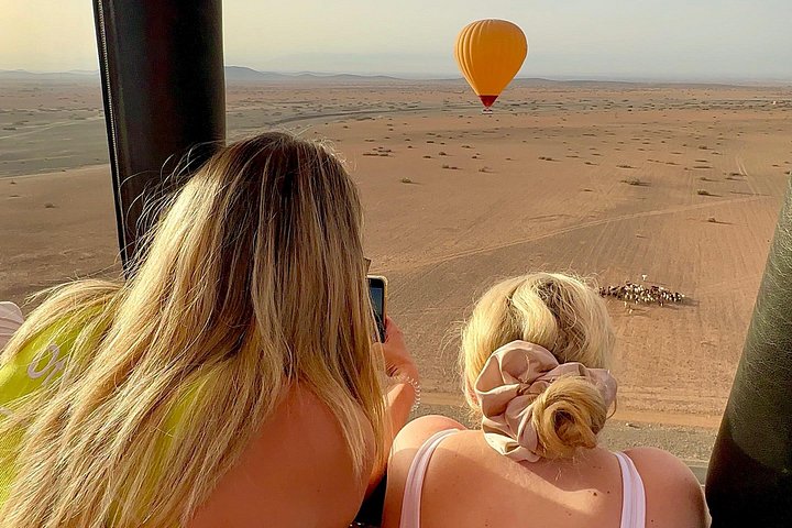 Hot air balloon floating over Marrakech at sunrise with Atlas Mountains view, photo 40 | wizardtrip