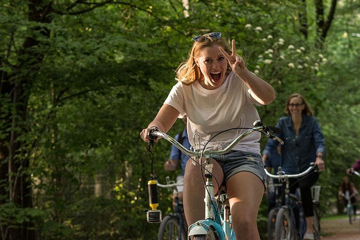 晴れた日、グループが中華タワーを通り過ぎながらミュンヘンのイングリッシュガーデンをサイクリングしています、写真6 | wizardtrip