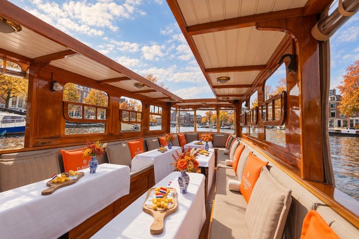 Classic saloon boat cruise on Amsterdam's historic canals, passing landmarks and enjoying drinks and cheese, photo 1 | wizardtrip