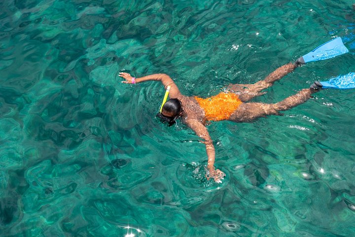 Een catamaran zeilt op turquoise wateren bij St Kitts, met mensen die snorkelen en lunchen, foto 7 | wizardtrip