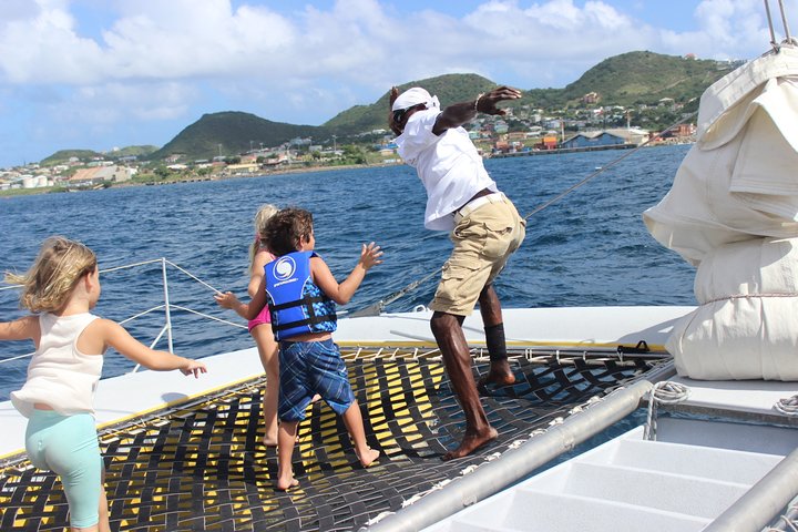 Een catamaran zeilt op turquoise wateren bij St Kitts, met mensen die snorkelen en lunchen, foto 8 | wizardtrip